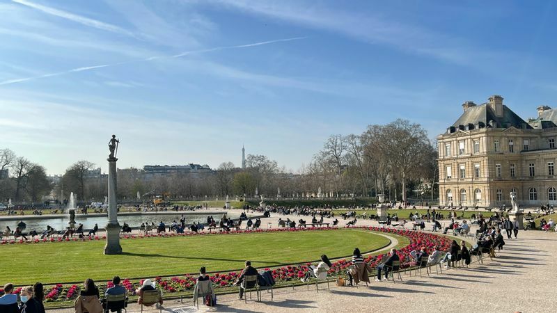 3月23日、パリ6区リュクサンブール公園。晴天の日は太陽を浴びようとするパリっ子たちで賑わう。右は上院議会の建物