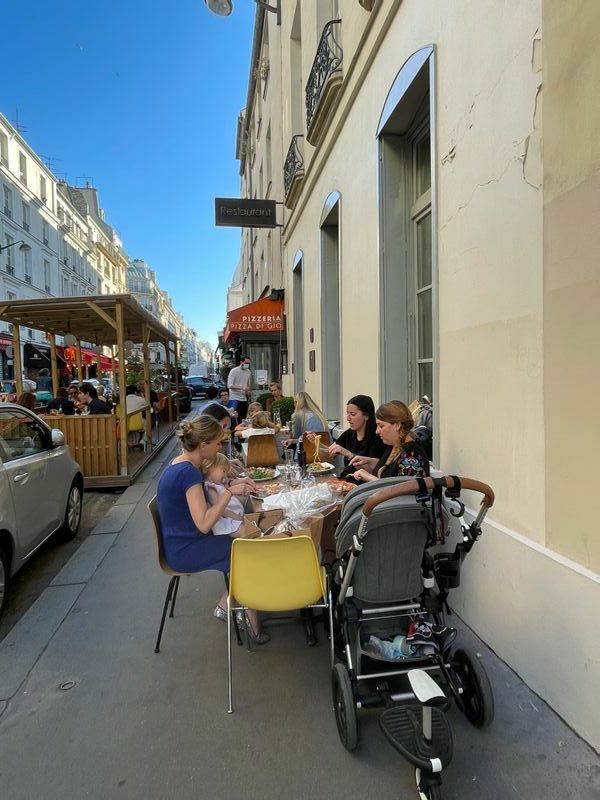 パリ6区、シェルシュミディ通り。レストランの前の車道だけでなく、横の建物の壁際にもテラス席が。21時の夜間外出制限までのあいだに戸外で夕食を楽しむ人たち