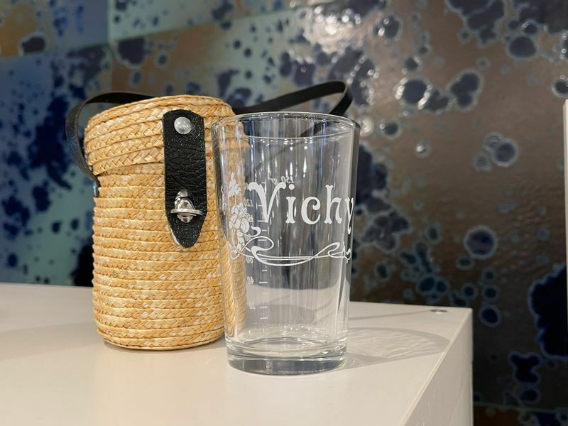 源泉水は持参した紙コップなどでも飲めるが、専用のバスケット入りご当地グラスもヴィシー各所で販売されている。