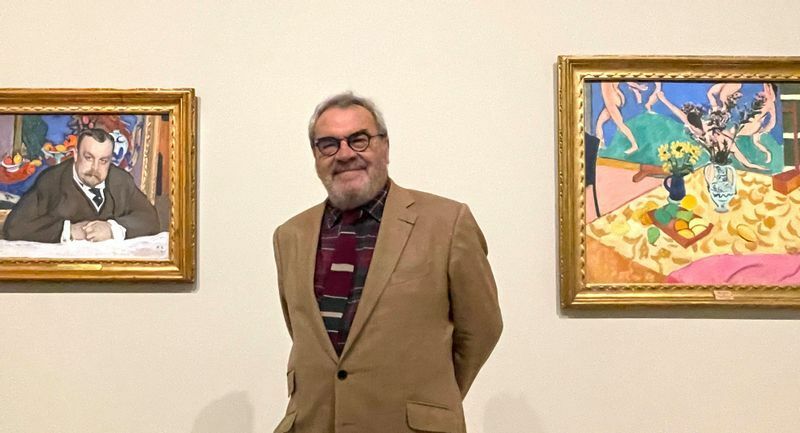 セルゲイ・シチューキンの孫、アンドレ＝マーク・ドゥロック＝フルコーさん。彼の左の絵はイワン・モロゾフの肖像画。右はマティスの作品で代表作『ダンス』のある風景を描いたもの。いずれもイワンのコレクション。