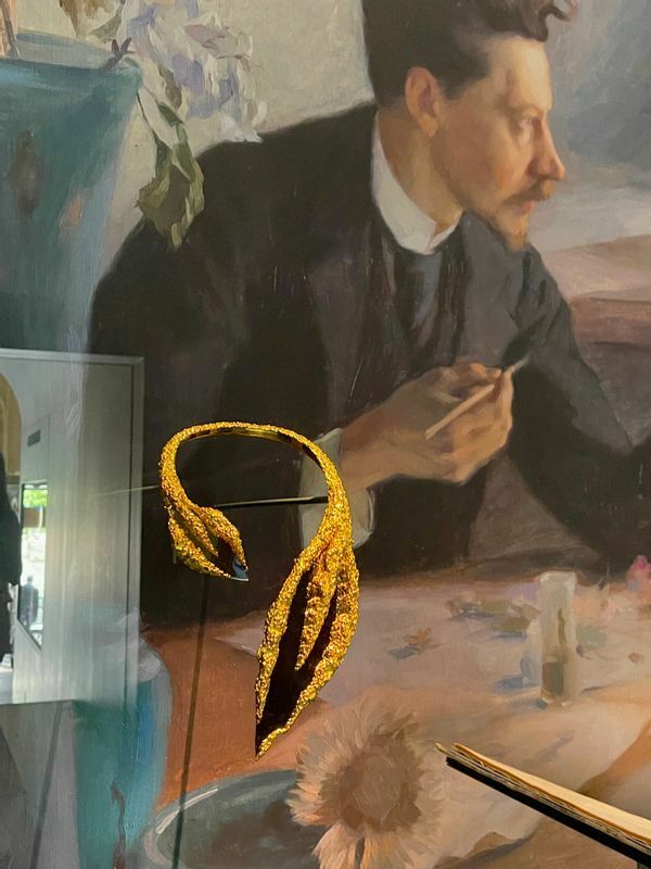 蔓植物をモチーフにした「ショーメ」1970年制作のネックレスと、アール・ヌーヴォーの中心人物の一人、エミール・ガレの肖像画が一つのケースに飾られた演出