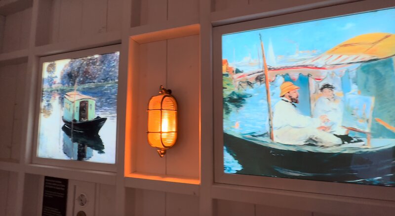 「アトリエ舟」とそこで制作中のモネの様子が壁面に映し出されている