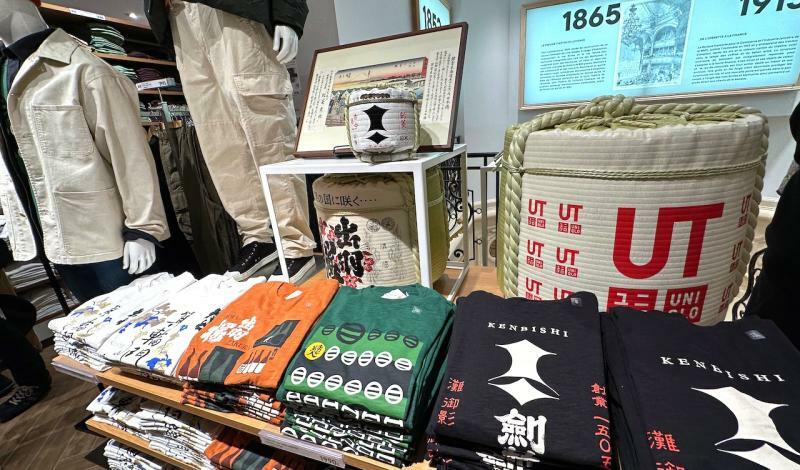 日本各地の銘酒のロゴがデザインされたオリジナルTシャツとともに菰樽がディスプレイされた「ユニクロ オペラ」（筆者撮影）
