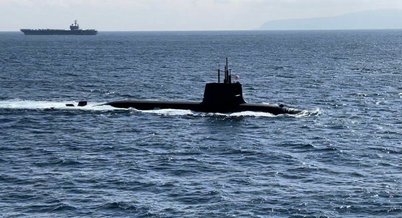 国際観艦式2022で受閲艦艇部隊の1隻として航行する海上自衛隊の最新型潜水艦たいげい。左奥に見えるのは米原子力空母のロナルド・レーガン（高橋浩祐撮影）