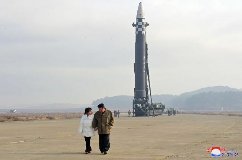 発射前の新型ICBM「火星17」の近くで手を繋いで歩く金正恩総書記と娘（KCNA）