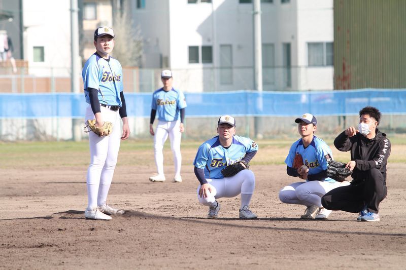 投内連携で投手陣に助言する赤間さん(右)