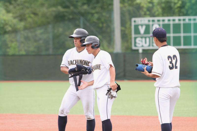 試合では一塁のベースコーチに入る田口（中）。八戸学院大の学生コーチとしてはリーグ優勝に向けて仲間と邁進する（筆者撮影）