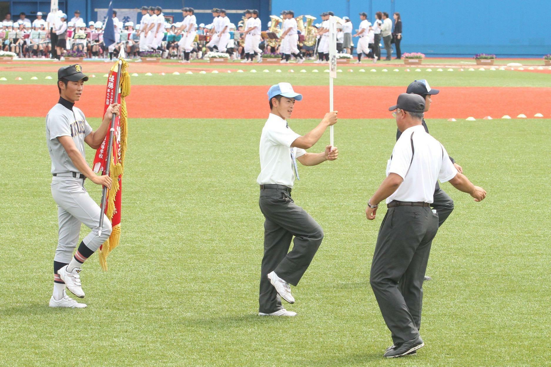 石巻市民球場で行われた2013年の宮城大会の開会式。仙台育英の3年生だった航平さん（中）はプラカードを持って入場行進し、誘導する係だった水沼先生（右、当時は石巻商監督）と目が合う。左は中日・上林