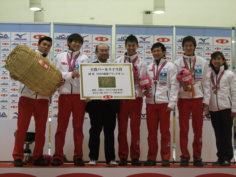 第30回全農日本カーリング選手権大会で優勝した際のひとコマ。米俵を抱いているのが山口だ。（著者撮影）
