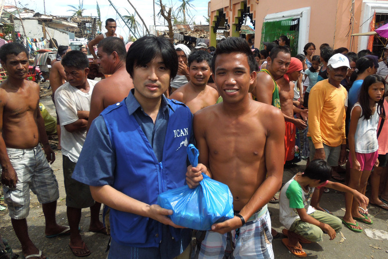 被災者に支援物資を手渡す日本人スタッフ（ICAN提供）