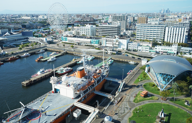 名古屋港の展望施設からの眺望。右奥は名古屋駅前の高層ビル群。左側の観覧車との間の奥に、掖済会病院が立地する（筆者撮影）
