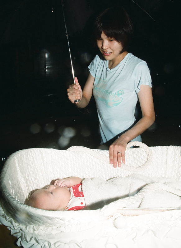 赤ちゃんを気にしながら冠水した道路を歩く藤岡美貴子さん（2000年9月12日、花井知之撮影）