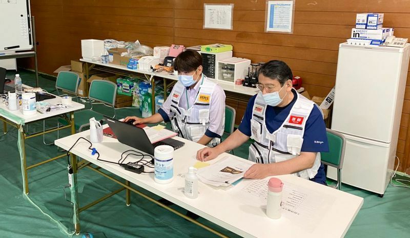第5波の患者増加を受け、愛知県武道館に設置された入院待機ステーションで業務に当たる北川医師ら（名古屋掖済会病院提供）