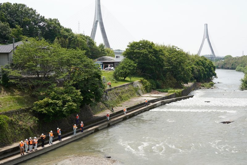 水が噴き出す下流側を調査する国交省の職員やコンクリートの専門家（2022年5月19日、筆者撮影）