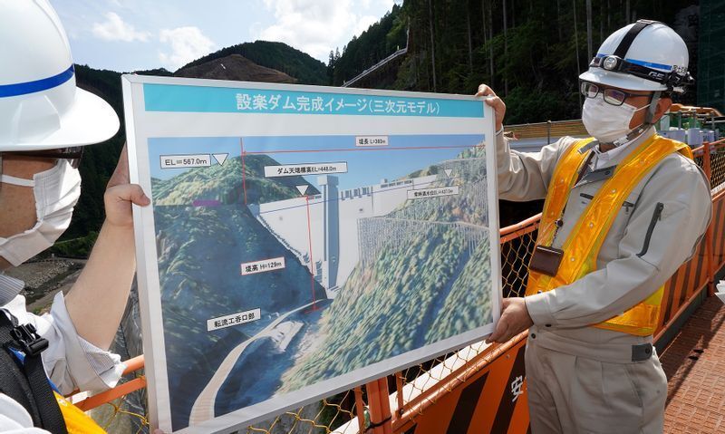 逆三角のダム本体が、谷間を仕切るように建設される。運用開始後は手前に水が貯まってダム湖になる(2022年5月27日、筆者撮影)
