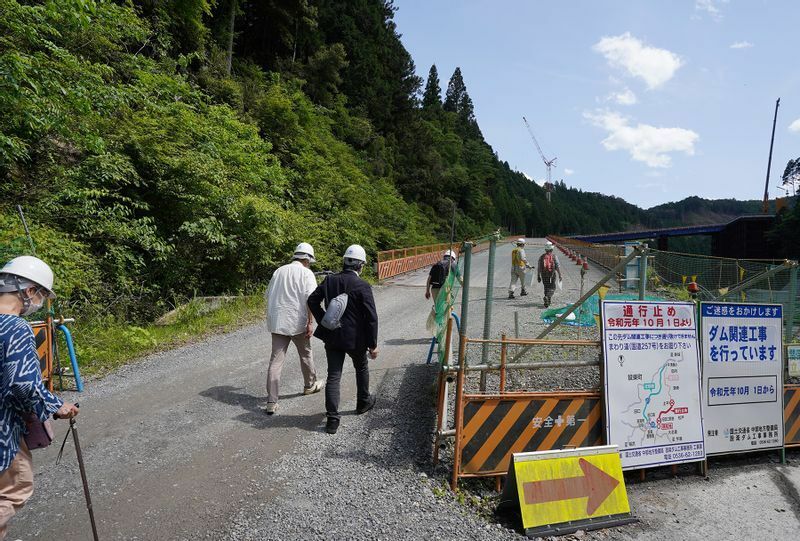 設楽ダム建設現場の工事用道路を歩いて上る参加者たち（2022年5月27日、筆者撮影）