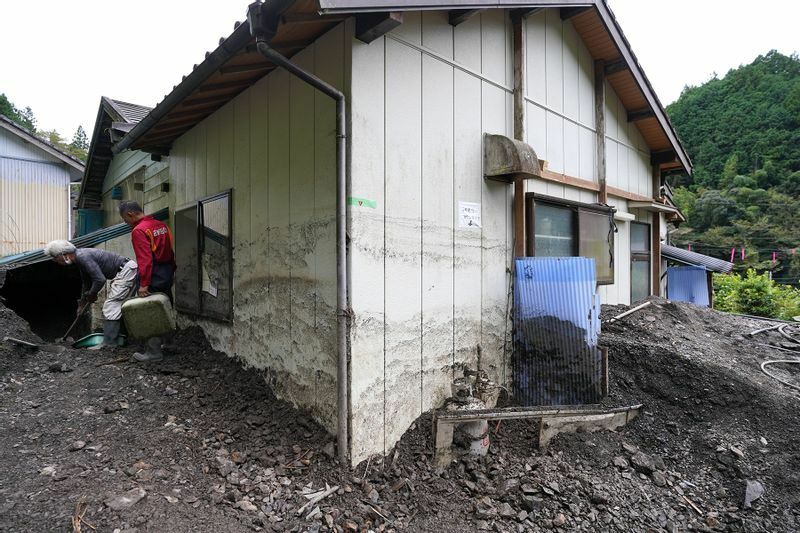 清沢地区では土砂で1階の窓の半分が埋まった家屋もあり、地域の人たちが手作業で土砂をかき出していた。沢の水から取っていた生活用水もパイプが破損して使えなくなっているという（10月9日、筆者撮影）