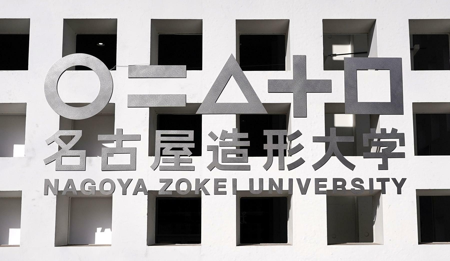 名古屋造形大学の新キャンパスには、山本の提唱でこれまでの9つの「コース」を5つの「領域」に再編したことを「○」や「＝」などの記号で表したロゴが掲げられている＝2024年2月8日、筆者撮影