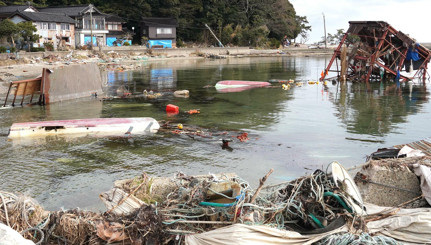 津波で大きな被害を受けた布浦地区の漁港。奥に並ぶ建物の右端が滝田さんの自宅＝2月4日、筆者撮影