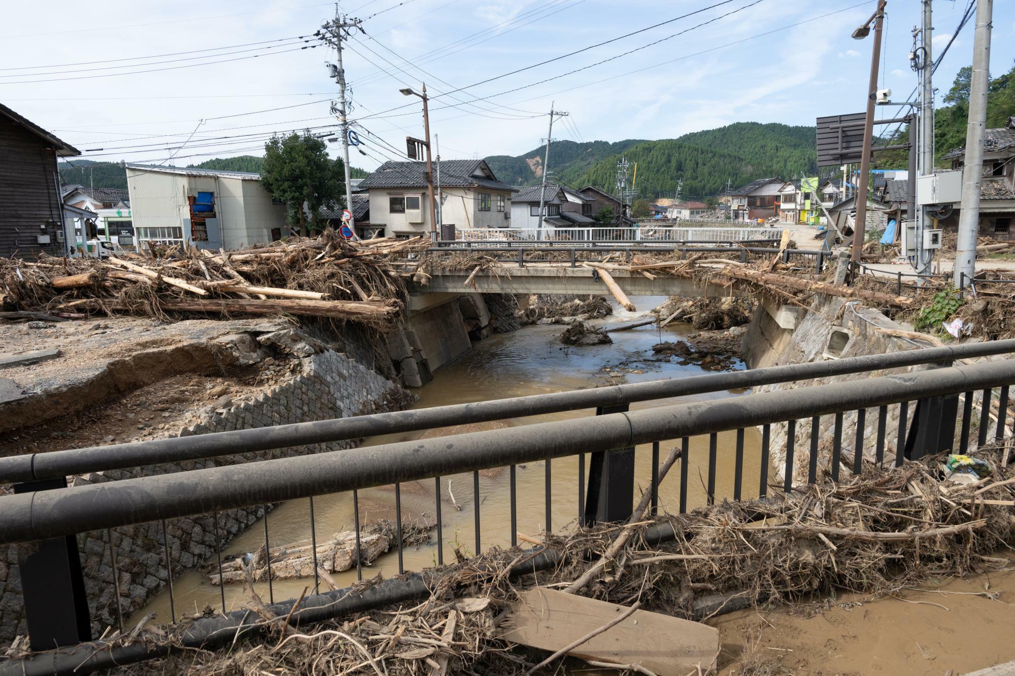 町野町の中心部を流れる鈴屋川は激しく氾濫し、護岸や橋の欄干に大量の流木が絡みついていた＝9月29日、夏目健司撮影