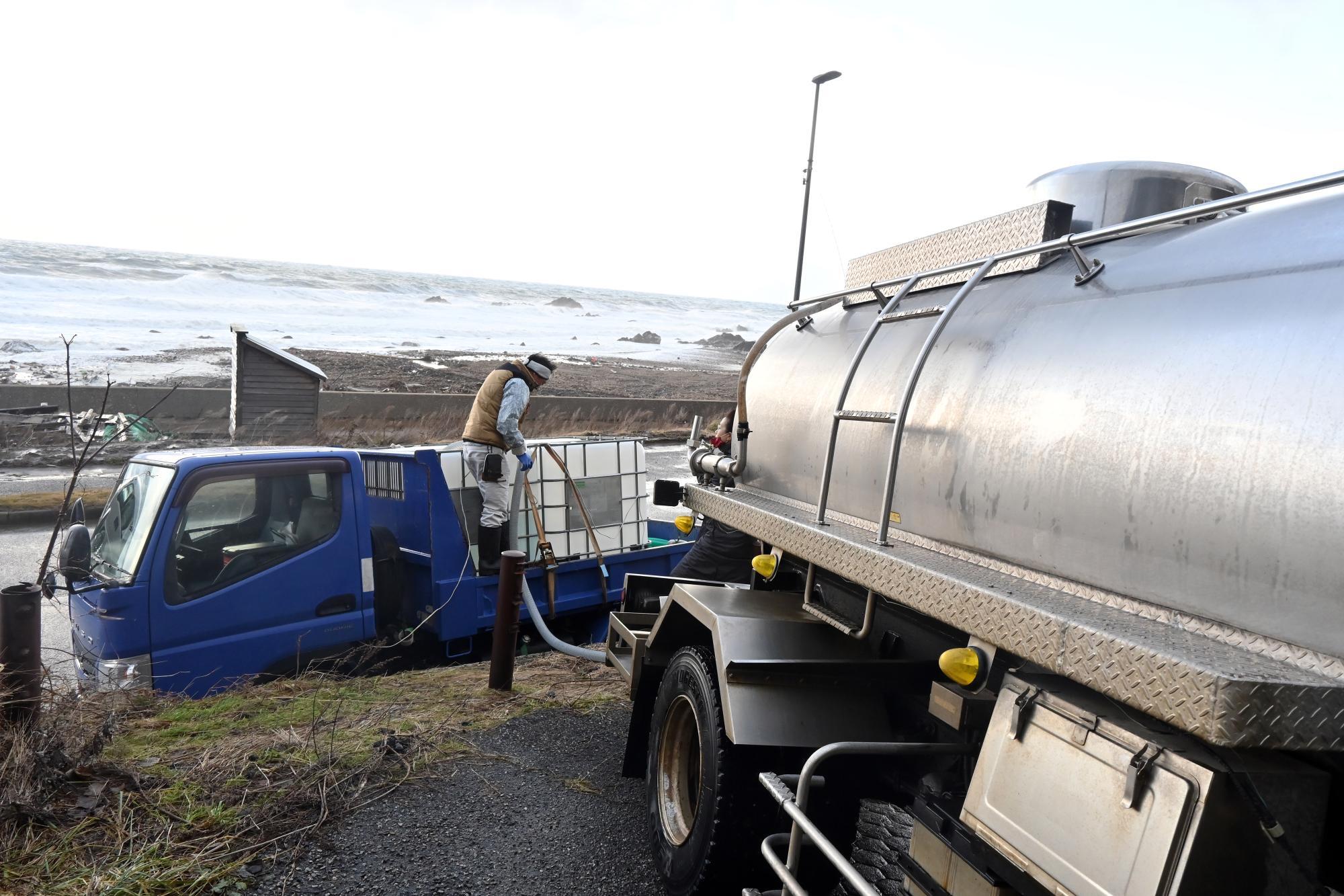 手前の4トンの給水車から水を補充する「瀬取り」＝12月22日、加藤直人撮影