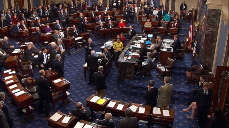 トランプ政権による”オバマケア改廃”に対して、マケイン上院議員は反対票を投じた。写真中央、腕を伸ばして立つ後ろ姿がマケイン。彼の１票で、法案は49対51で否決される。（2017年7月27日）