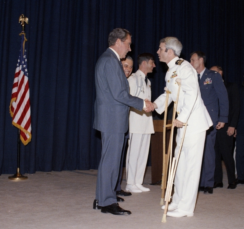 ニクソン大統領に面会（1973年5月24日）。海軍パイロットとしてベトナム戦争に。捕虜として5年間抑留され、拷問される。