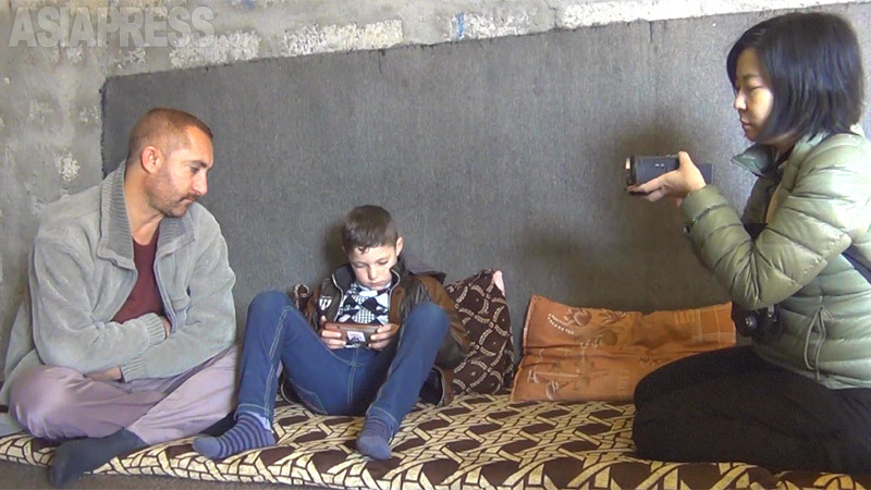 次男の解放から10日後、家族のもとを取材。だが彼は父を拒み、会話をしなかった。携帯ゲームばかりして、心を閉ざした状態だった。（2017年2月・クルド自治区・撮影：アブダル・アリ）