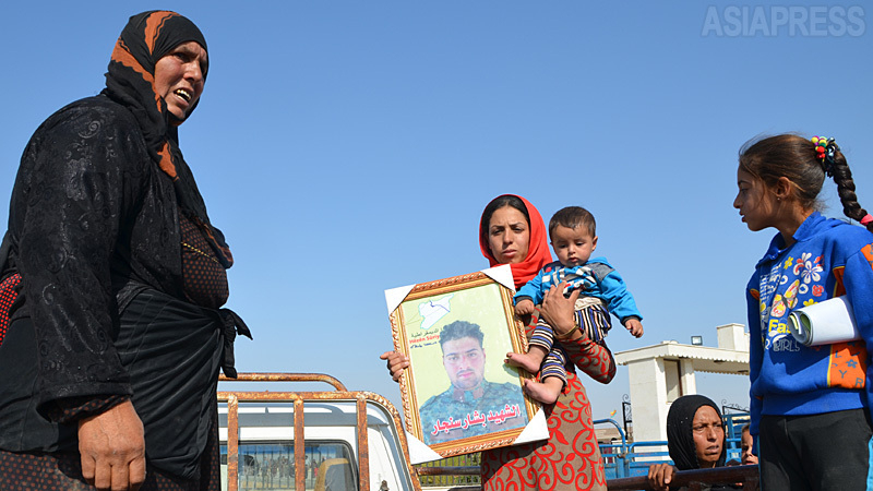 戦闘では双方に犠牲者があいついでいる。中央は戦死したシリア民主軍の夫の写真を抱える妻。（2019年10月・シリア、テル・タミル　玉本撮影）