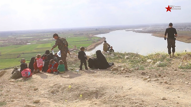 シリア民主軍に拘束、保護されるＩＳ家族。後ろはユーフラテス川。ＩＳ信奉者もいれば、夫についてきただけという妻も。（2019年・ＹＰＪ映像）