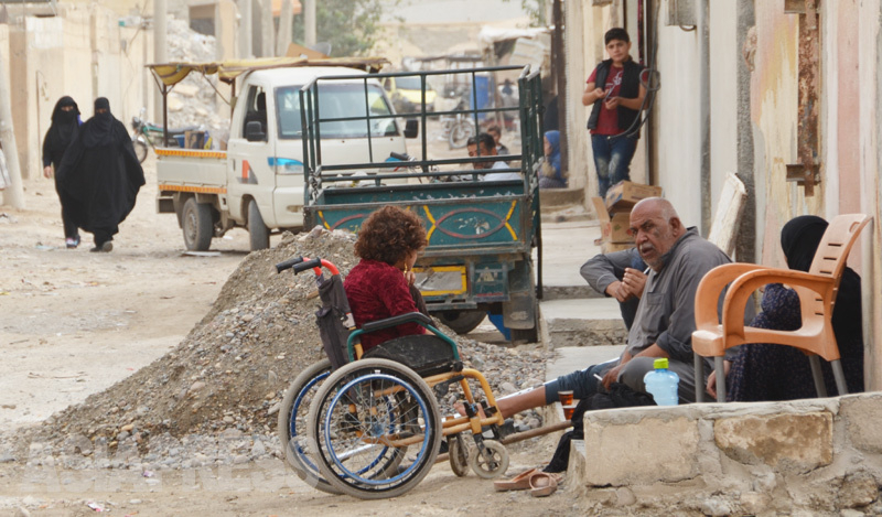 ラッカの学校は再開したが、ファティマの家からは遠く、車椅子では通えなかった。ずっと家の前の路地で道行く人を眺めながら一日を過ごす日々だった。（2018年10月・シリア・ラッカ・玉本英子撮影）