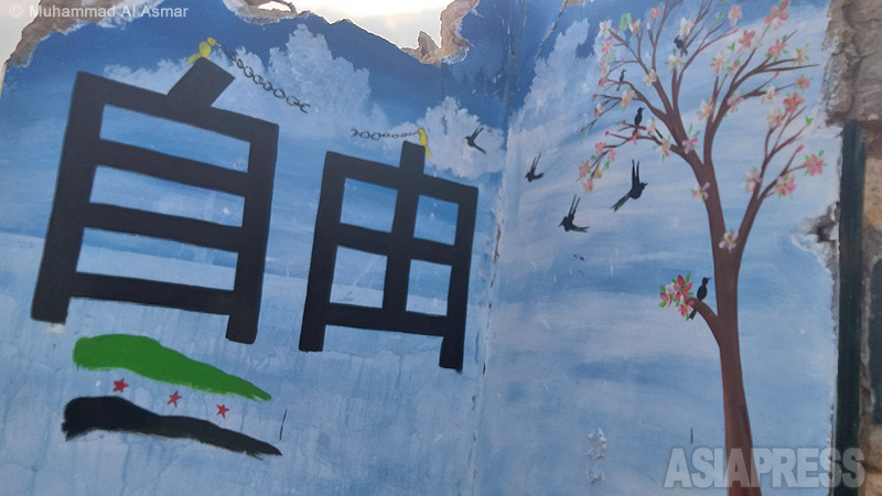 めぐみさんの肖像とともに「自由」の文字と桜も。この壁画は、イドリブ近郊の町、ビンニシュで描かれた。（2020年11月・撮影：ムハンマド・アル・アスマール）