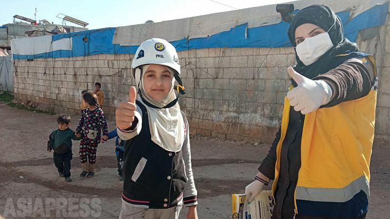 アスマさん（右）は避難民キャンプを中心に活動。「大きくなったら、私もホワイトヘルメットに入りたい」と話す女の子にヘルメットをかぶせてあげてポーズ。（2021年4月、同僚隊員撮影）