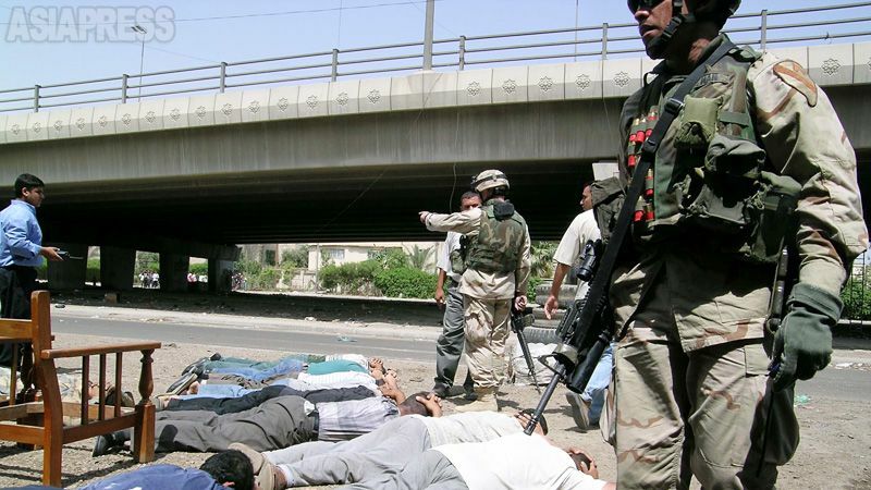 「テロとの戦い」は、のちに大量破壊兵器を隠し持っているとしたイラクに及ぶ。フセイン政権崩壊後、武装勢力の攻撃が激化。写真は爆弾事件で周辺住民を一時拘束する米軍。こうしたやり方に、住民の反発が広がった。（イラク、バグダッド・2004年5月・撮影：坂本卓）