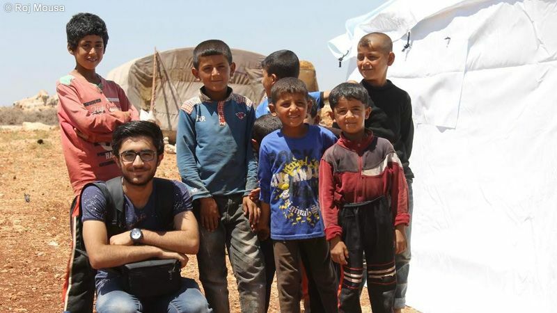 戦火は破壊をもたらし、たくさんの避難民を生み出す。写真は、記者としてアフリンから逃れてきた人たちが身を寄せる避難民キャンプを取材した当時のロジさん。（写真：2016年・ロジさん提供）
