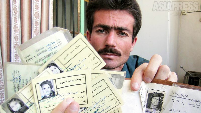 【イラク】 イラクでは1988年、クルド人の町ハラブジャで政府軍が化学兵器爆弾を使用。住民5000人が死亡したが、フセイン政権（当時）は関与を否定。写真は、亡くなった家族の身分証を見せる男性。（2003年・イラク北東ハラブジャ・撮影：玉本英子）
