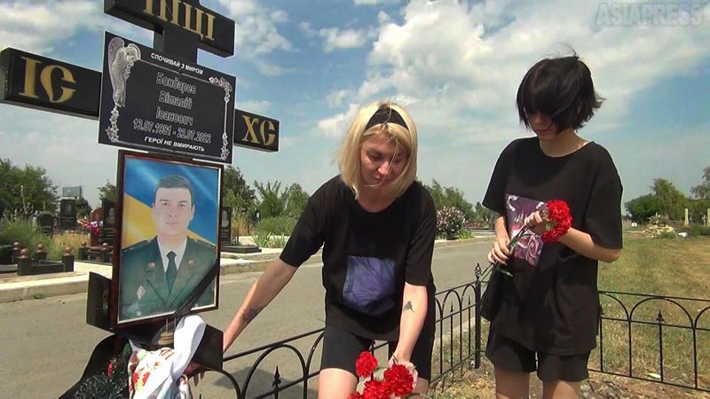 ヴィターリーさんの墓前に花を手向けるダーシャさんと母イリーナさん。（2022年8月・オデーサ・撮影：坂本卓）