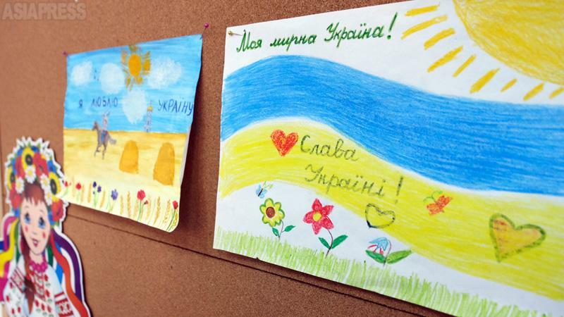 学校の低学年児童の教室にあった絵には、輝く太陽と大地に咲いた花とともに、「ウクライナに栄光あれ」「私の平和なウクライナ」と書き添えてあった。（2022年８月・オデーサ・撮影：坂本卓）
