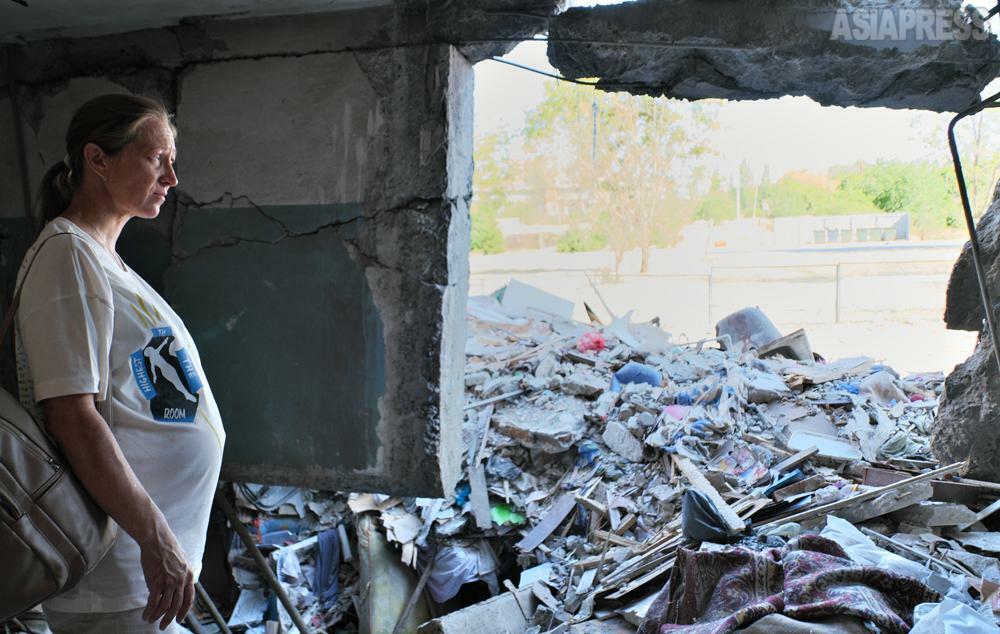 ロシア軍のミサイル攻撃で破壊された部屋の前に立つ妊婦。(2022年7月・ウクライナ・セルヒーウカ・撮影：玉本英子）