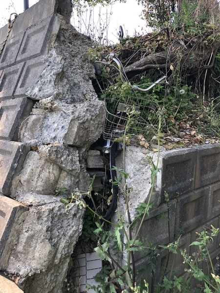 地震によって擁壁が破壊されていた。挟まった自転車が地震の強さを物語る＝2019年4月、熊本県益城町（田中森士撮影）