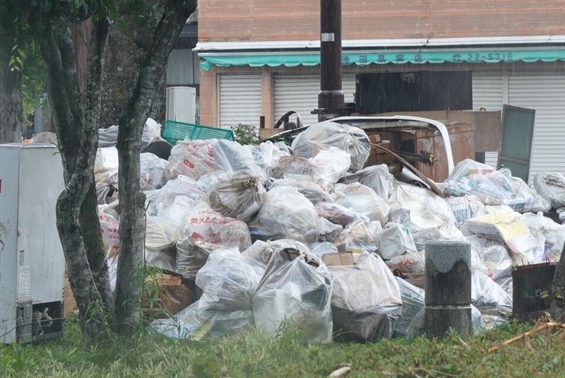 道路脇にはゴミ袋が積み上がっていた=5日、熊本県人吉市