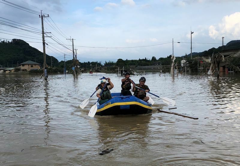 水につかった人吉市内でボートを漕ぐ加盟業者ら＝2020年7月4日（球磨川ラフティング協会提供）