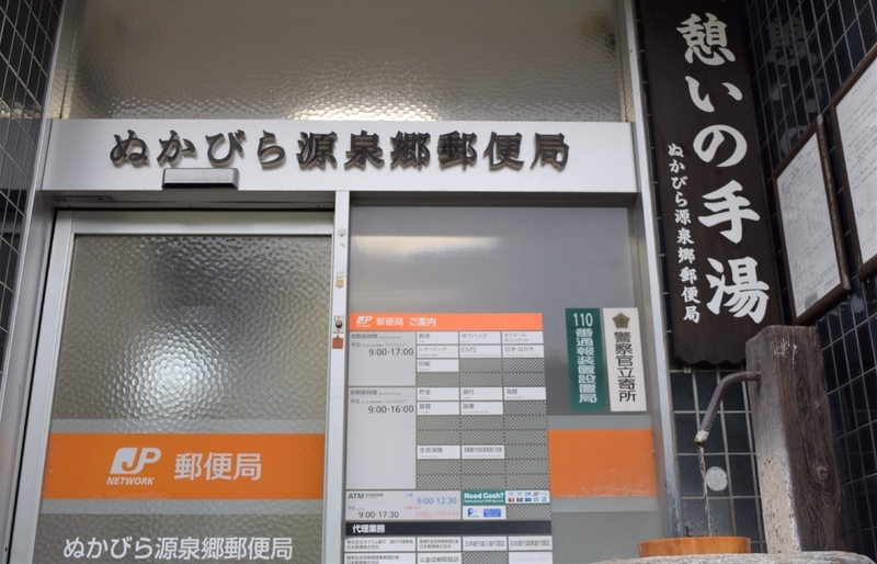 手湯がある、ぬかびら源泉郷郵便局。立つと自動ドアが開くのに苦笑。アーチ橋の絵はがきや写真集も販売。希望すると投函に風景入り記念通信日付印を押してくれる／筆者撮影