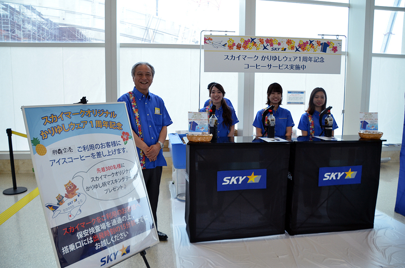那覇空港チェックインカウンター前で、スカイマークの市江正彦社長やスタッフがお客様へアイスコーヒーなどを無料配布した