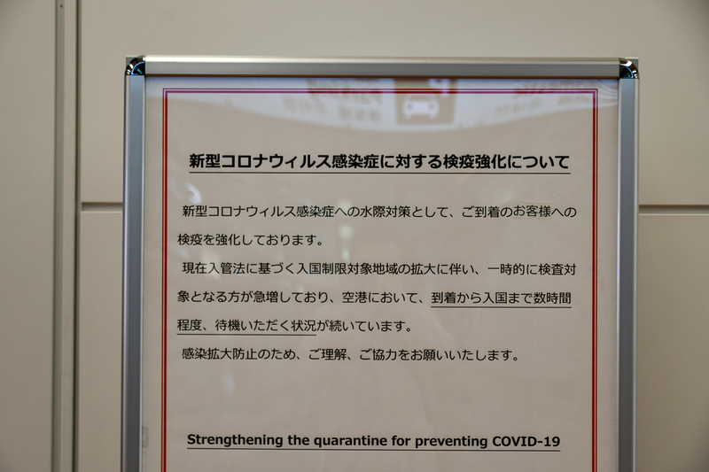 到着ロビーには入国に時間を要する旨が掲示されている（羽田空港第2ターミナル、国際線到着ロビーにて撮影）