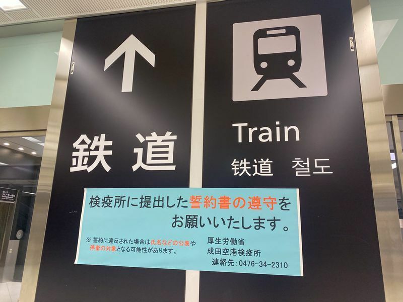 成田空港の鉄道駅へ向かう通路でも誓約書の遵守を求める案内も出ているが（2021年12月、筆者撮影）