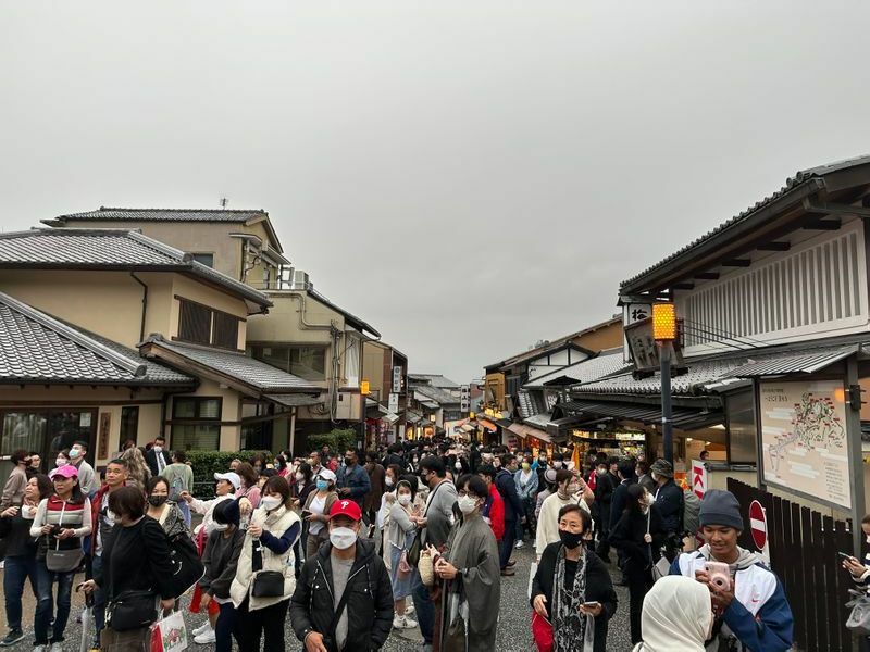 京都の清水寺へ向かう参道には多くの人が。土産店では多くのお店で使えるが飲食店で使えないお店も多い。修学旅行でも全国旅行支援が適用可能で学生にもクーポンが渡され、お土産購入の姿も（11月13日筆者撮影）