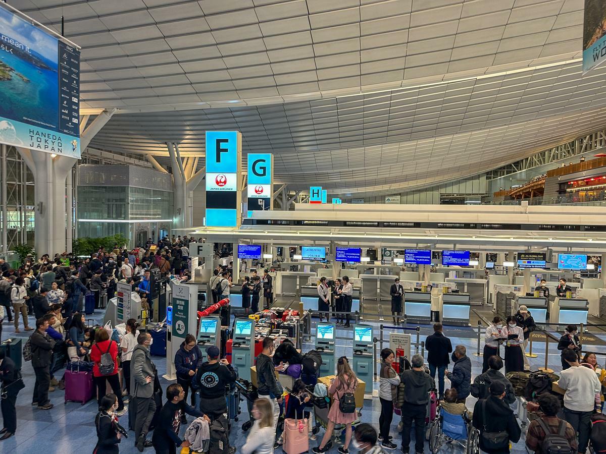 国際線が発着する羽田空港第3ターミナルでは、多くの便が欠航ではなく大幅遅延での対応となった。搭乗手続きを一時中止していたチェックインカウンター（1月2日22時10分、筆者撮影）