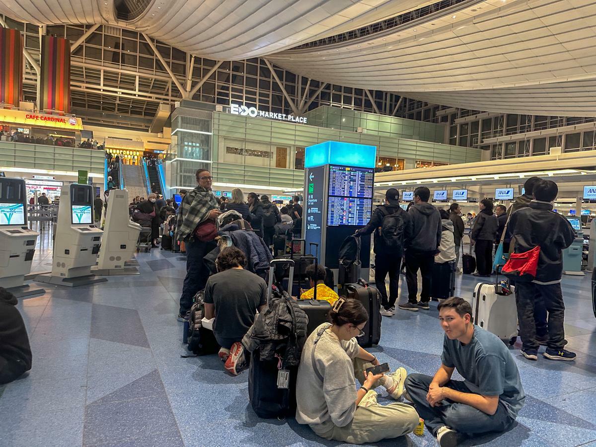 羽田空港第3ターミナルで国際線チェックインの再開を待つ訪日外国人観光客の姿も目立った（1月2日21時30分、筆者撮影）
