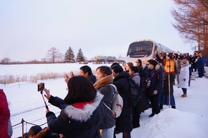釧網本線の茅沼駅でカメラを構える外国人観光客。（撮影：大熊一精氏）